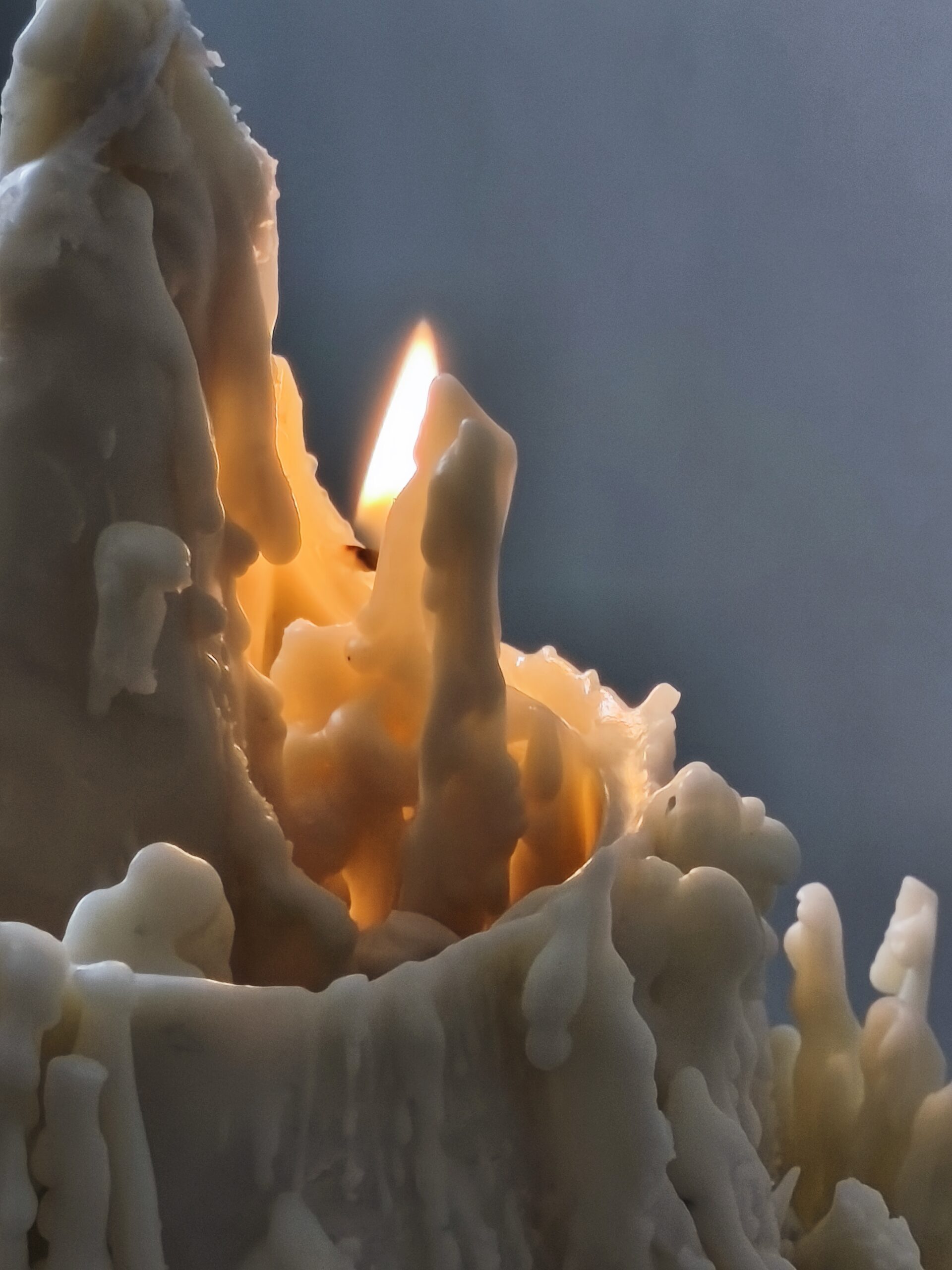 Sculpture lumineuse CIME MÉORAH en combustion, révélant des reliefs de cire inspirés des montagnes savoyardes.